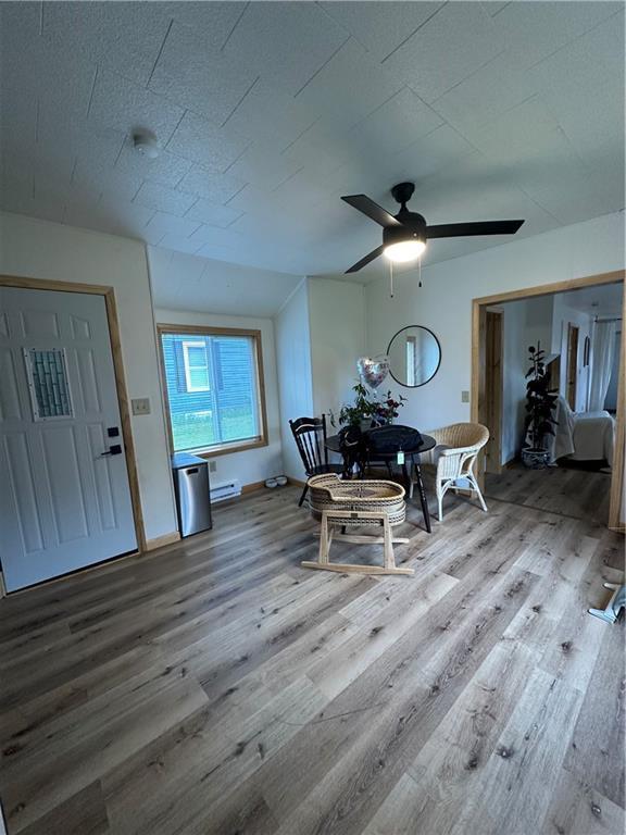 1010 Fillmore St, Black River Falls, WI 54615 - dining room featuring wood finished floors, a baseboard heating unit, and a ceiling fan