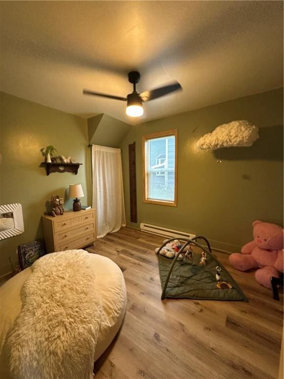 1010 Fillmore St, Black River Falls, WI 54615 - bedroom featuring a baseboard heating unit, light wood-style floors, and ceiling fan