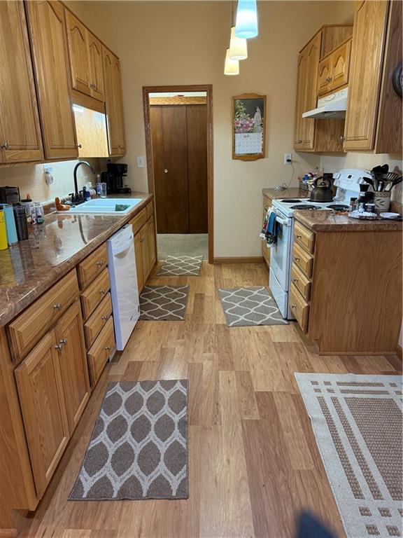 410-4101/2 W Elm St, Chippewa Falls, WI 54729 - kitchen with white appliances, a sink, under cabinet range hood, light wood-style flooring, and brown cabinets