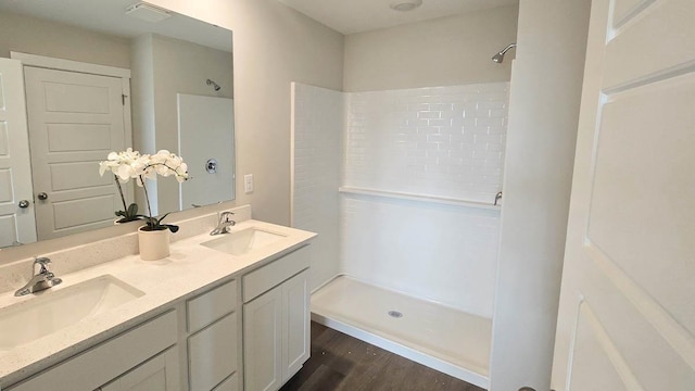 509 Oak Opening Dr, Stoughton, WI 53589 - bathroom featuring a shower, double vanity, and wood finished floors