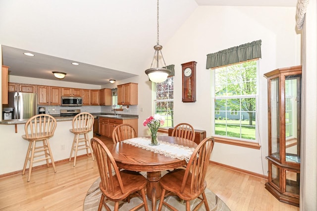 9165 S 47th St, Franklin, WI 53132 - dining space featuring light wood finished floors, healthy amount of natural light, baseboards, recessed lighting, and high vaulted ceiling