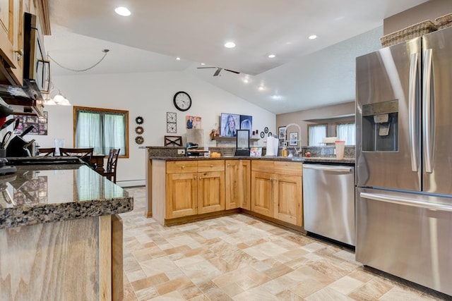 4100 15th St, Menominee, MI 49858 - kitchen with stainless steel appliances, vaulted ceiling, dark stone countertops, light stone finish flooring, and recessed lighting