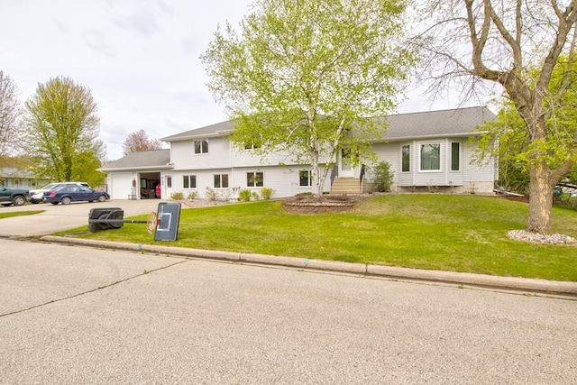 4100 15th St, Menominee, MI 49858 - view of front of house featuring an attached garage, concrete driveway, and a front lawn