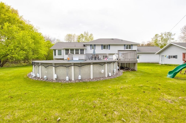 4100 15th St, Menominee, MI 49858 - back of house with a playground, an outdoor pool, a lawn, and a deck