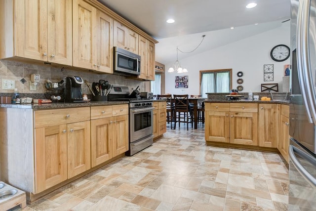 4100 15th St, Menominee, MI 49858 - kitchen featuring appliances with stainless steel finishes, lofted ceiling, decorative backsplash, a chandelier, and a peninsula