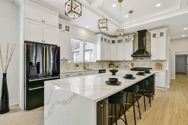 10500 W Vera Ave, Milwaukee, WI 53224 - kitchen featuring black fridge with ice dispenser, wall chimney exhaust hood, a sink, light wood finished floors, and recessed lighting