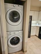 35 Harborview Dr Unit 108, Racine, WI 53403 - washroom featuring stacked washing machine and dryer and light tile patterned floors
