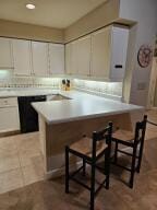 35 Harborview Dr Unit 108, Racine, WI 53403 - kitchen featuring a breakfast bar, light countertops, a peninsula, and tile patterned flooring