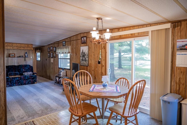 2146 Olmstead St, Friendship, WI 53934 - dining space with wooden walls, a chandelier, vaulted ceiling, and carpet floors