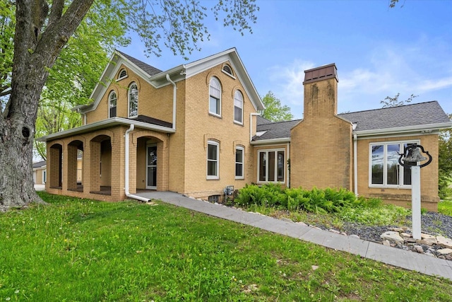 6600 N Ballard Rd, Appleton, WI 54913 - traditional home with brick siding, a front lawn, covered porch, a chimney, and roof with shingles