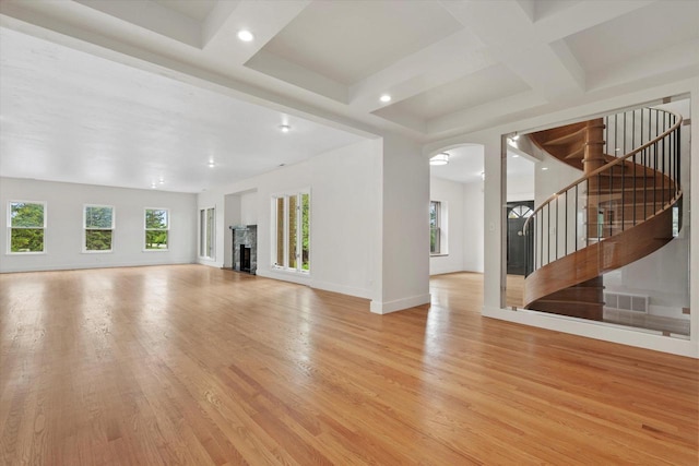 6600 N Ballard Rd, Appleton, WI 54913 - unfurnished living room with coffered ceiling, light wood-style floors, arched walkways, healthy amount of natural light, and beam ceiling