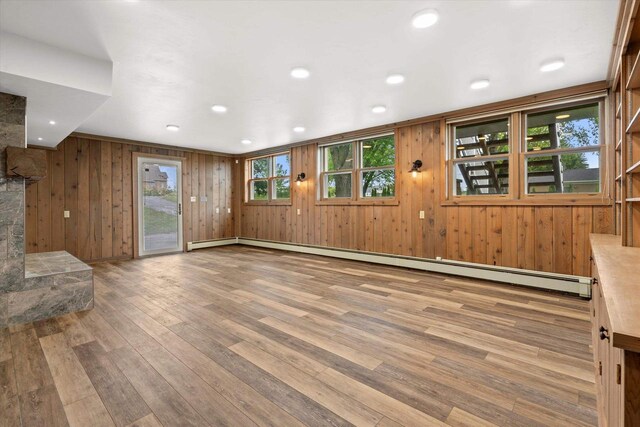 6600 N Ballard Rd, Appleton, WI 54913 - unfurnished living room featuring wood finished floors, healthy amount of natural light, a baseboard radiator, and wood walls