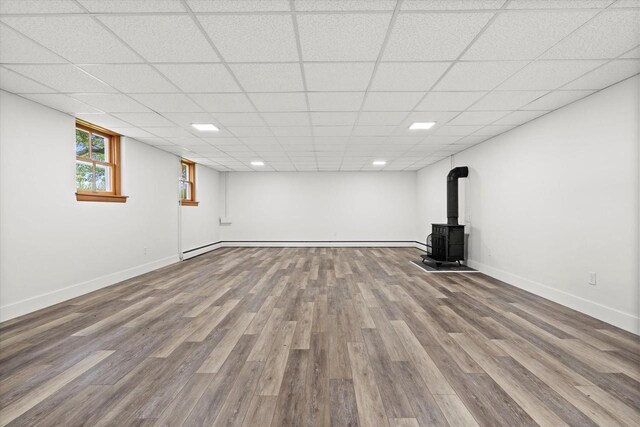 6600 N Ballard Rd, Appleton, WI 54913 - basement featuring a wood stove, wood finished floors, and baseboards