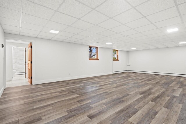 6600 N Ballard Rd, Appleton, WI 54913 - basement with wood finished floors, a baseboard radiator, baseboards, and a paneled ceiling