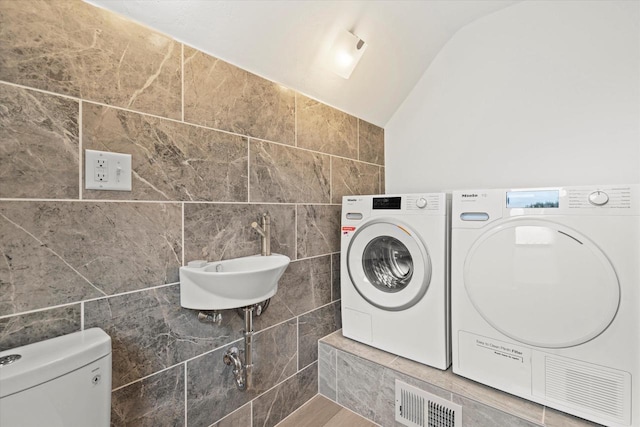 6600 N Ballard Rd, Appleton, WI 54913 - washroom featuring tile walls and separate washer and dryer