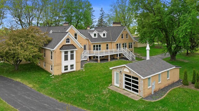 6600 N Ballard Rd, Appleton, WI 54913 - rear view of house with a chimney, a wooden deck, a garage, a yard, and an outbuilding