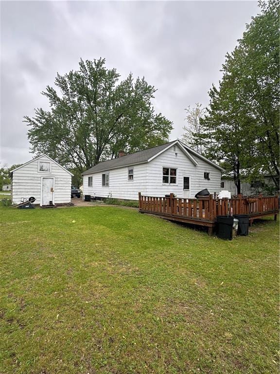 315 Armstrong Ave, Black River Falls, WI 54615 - rear view of house with a deck, a yard, and an outbuilding