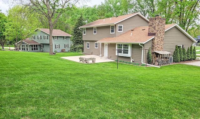 21755 W N Ave, Brookfield, WI 53045 - back of house with a patio, a chimney, a yard, and roof with shingles