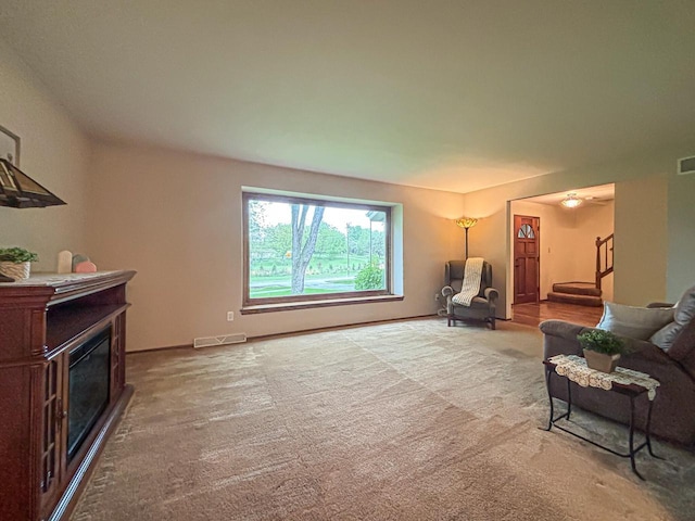 21755 W N Ave, Brookfield, WI 53045 - living area featuring a glass covered fireplace, carpet flooring, and stairway