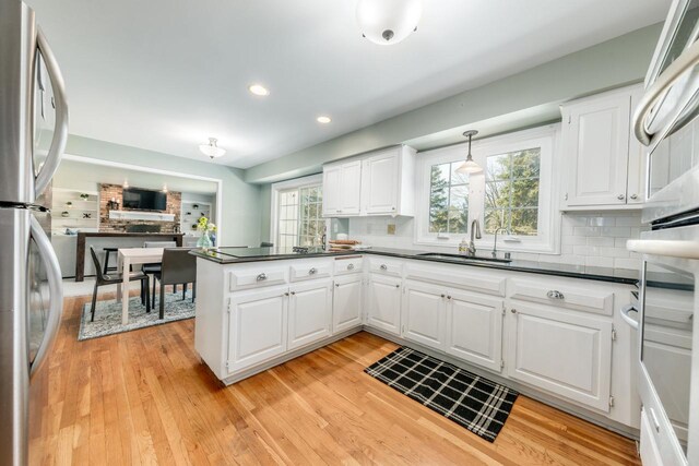 1305 Lexington Ct, Brookfield, WI 53045 - kitchen with a sink, dark countertops, decorative backsplash, white cabinets, and recessed lighting