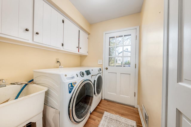 1305 Lexington Ct, Brookfield, WI 53045 - washroom with cabinet space, washer and clothes dryer, and light wood-style flooring