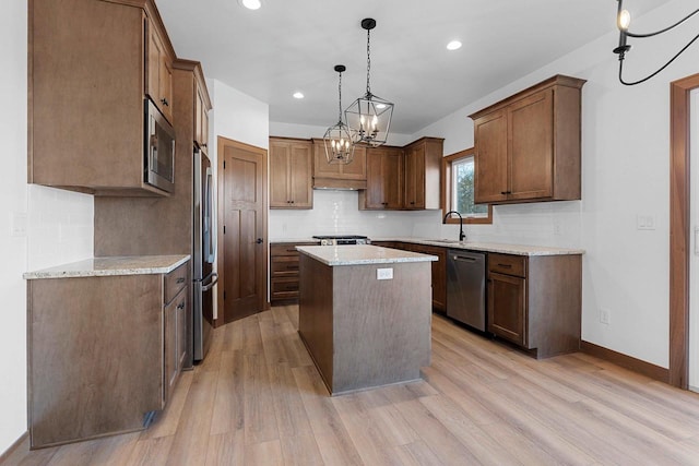 513 Kirkland Ave, Algoma, WI 54201 - kitchen with stainless steel appliances, a sink, a kitchen island, light wood finished floors, and recessed lighting
