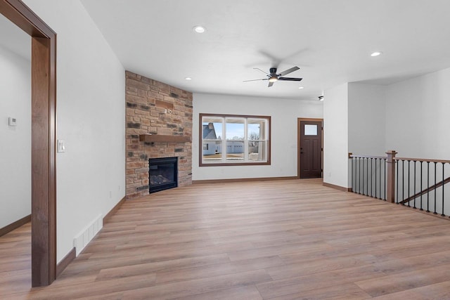 513 Kirkland Ave, Algoma, WI 54201 - unfurnished living room with a ceiling fan, light wood finished floors, recessed lighting, baseboards, and a fireplace