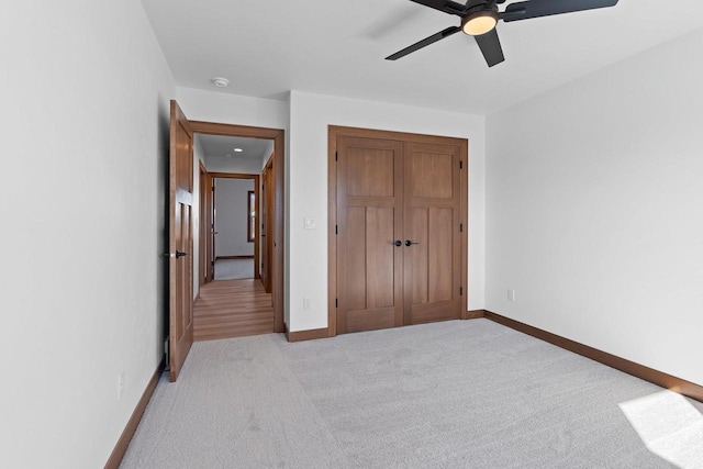 513 Kirkland Ave, Algoma, WI 54201 - unfurnished bedroom featuring light carpet, baseboards, a closet, and a ceiling fan
