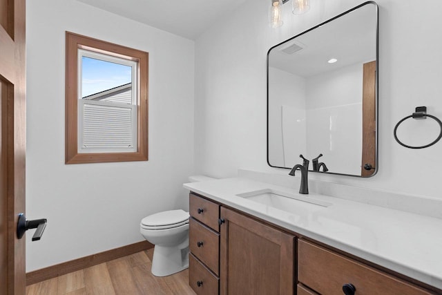 513 Kirkland Ave, Algoma, WI 54201 - bathroom with vanity, toilet, wood finished floors, and baseboards