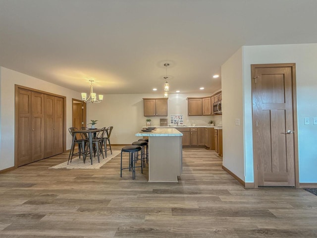 990 Morning Star Ln, Plover, WI 54467 - kitchen with light wood finished floors, recessed lighting, baseboards, a kitchen island, and a chandelier