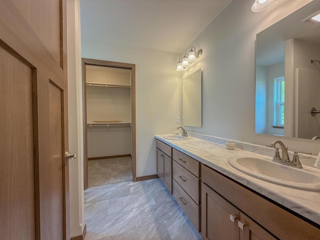 990 Morning Star Ln, Plover, WI 54467 - bathroom with double vanity, a spacious closet, and baseboards