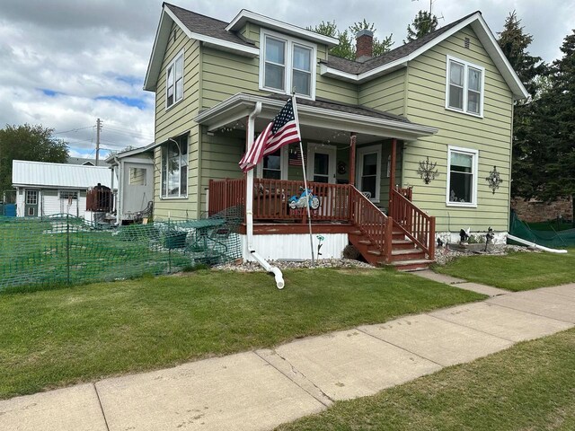 227 S 1st St, Colby, WI 54421 - view of front of house with covered porch, a chimney, a front lawn, and a shingled roof