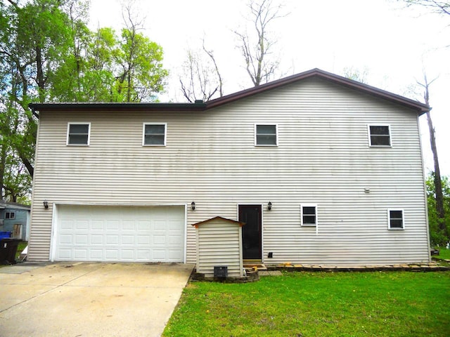 1129 Ember Dr, Adams, WI 53910 - rear view of property featuring an attached garage, a lawn, and concrete driveway