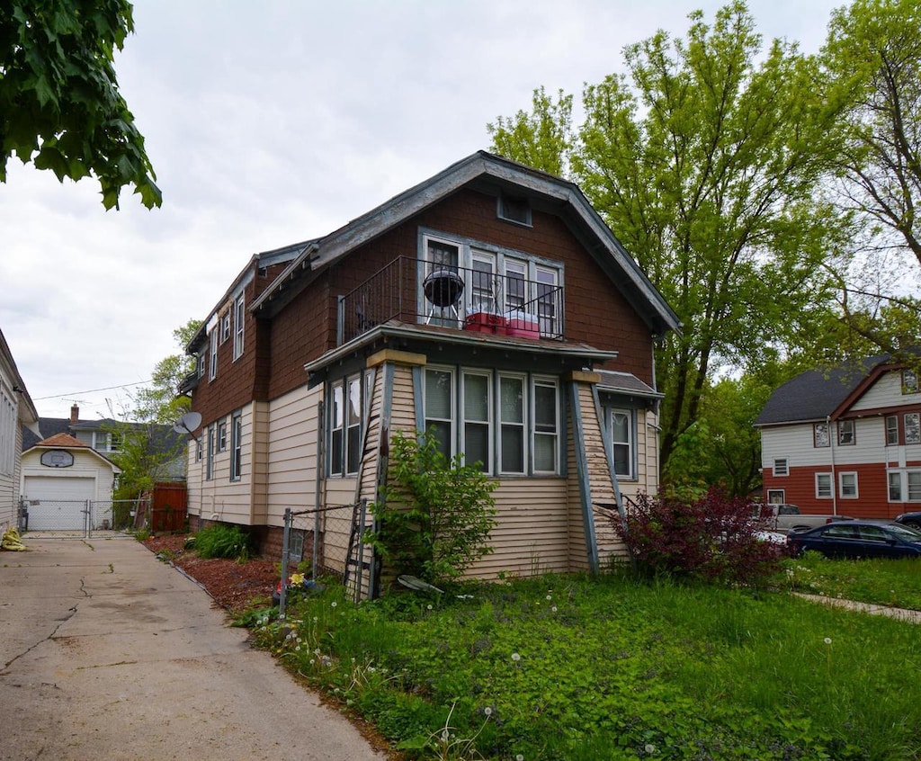 1902 W Nash St, Milwaukee, WI 53206 - view of front of house featuring a balcony, an outbuilding, driveway, and a garage