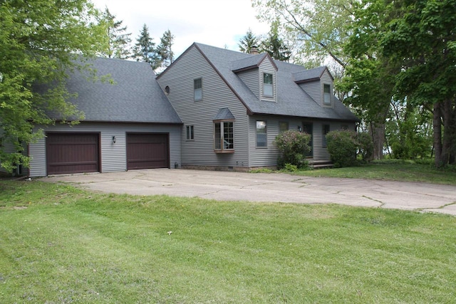 620 Oak St, Winneconne, WI 54986 - cape cod-style house featuring concrete driveway, roof with shingles, a front lawn, and an attached garage