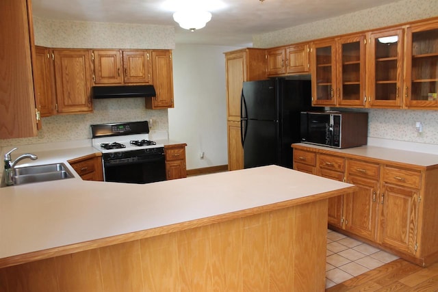 620 Oak St, Winneconne, WI 54986 - kitchen with range with gas cooktop, a sink, under cabinet range hood, freestanding refrigerator, and light countertops