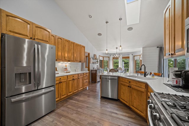 S91W35161 Prairie Ct, Eagle, WI 53119 - kitchen featuring stainless steel appliances, a sink, tasteful backsplash, dark wood-style floors, and brown cabinetry
