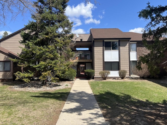 8629 N Servite Dr Unit 109, Milwaukee, WI 53223 - view of front of property featuring a front yard, a balcony, and roof with shingles
