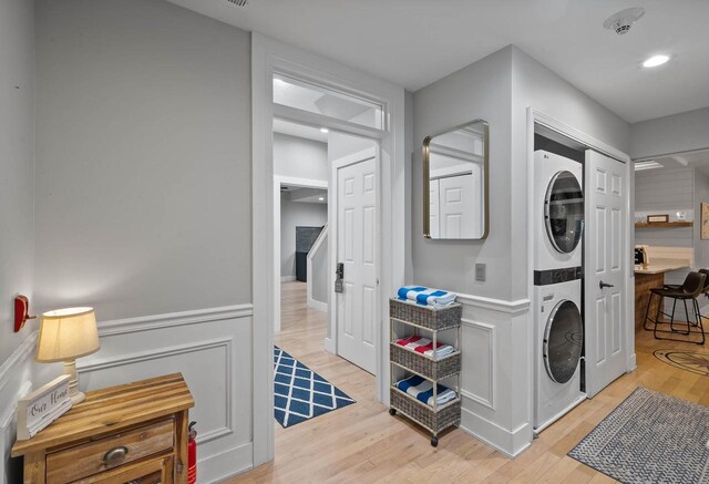 W3920 Lake Shore Dr, Lake Geneva, WI 53147 - washroom featuring stacked washer and clothes dryer, light wood finished floors, and a wainscoted wall