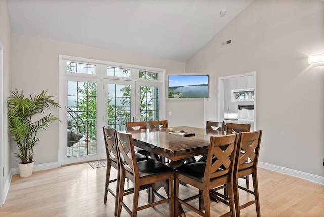 W3920 Lake Shore Dr, Lake Geneva, WI 53147 - dining room featuring light wood-style flooring, healthy amount of natural light, high vaulted ceiling, and baseboards
