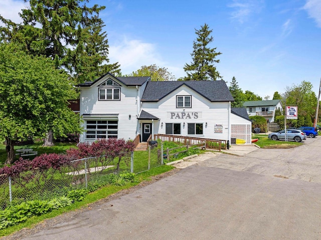 W3920 Lake Shore Dr, Lake Geneva, WI 53147 - view of front facade with a fenced front yard and roof with shingles