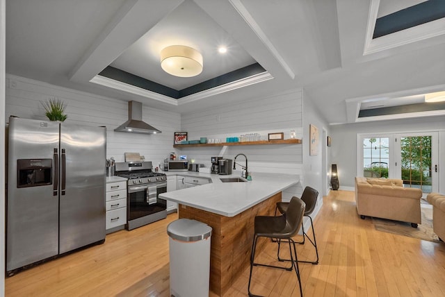 W3920 Lake Shore Dr, Lake Geneva, WI 53147 - kitchen with stainless steel appliances, wall chimney exhaust hood, a tray ceiling, a kitchen bar, and a peninsula