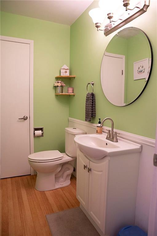 203 E Maple St, Thorp, WI 54771 - half bathroom featuring vanity, wood finished floors, and a chandelier