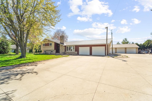 1116 Lake Park Rd, Menasha, WI 54952 - split level home with a chimney, a front lawn, stone siding, metal roof, and a detached garage