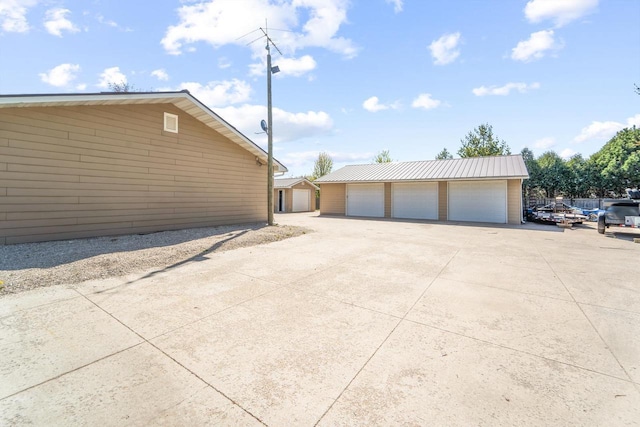 1116 Lake Park Rd, Menasha, WI 54952 - view of side of home with a garage, an outbuilding, and metal roof