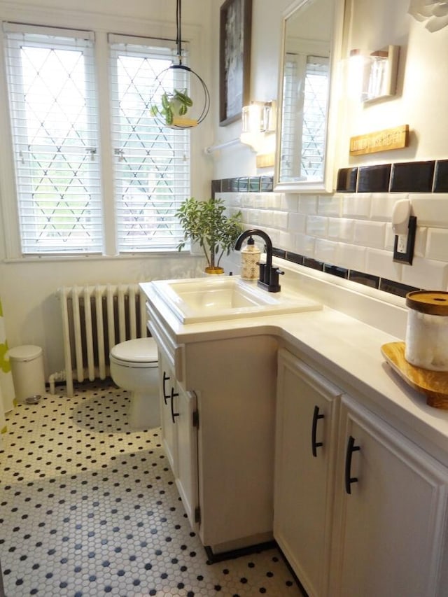 7320 5th Ave, Kenosha, WI 53143 - kitchen with radiator heating unit, a sink, hanging light fixtures, light countertops, and backsplash