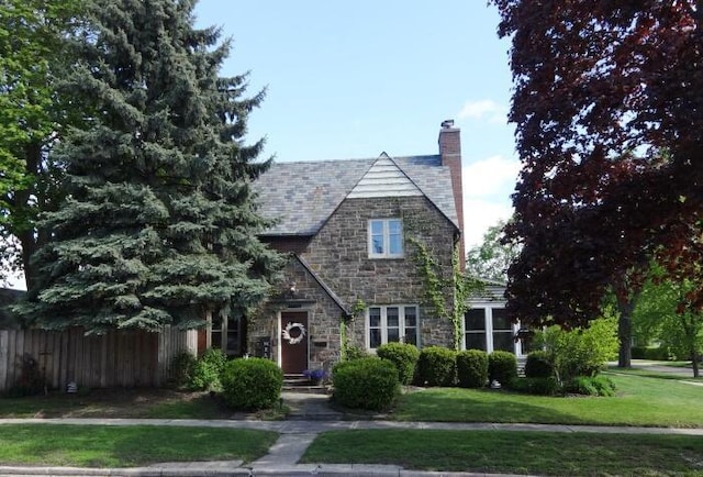 7320 5th Ave, Kenosha, WI 53143 - tudor house with stone siding, a chimney, and a high end roof