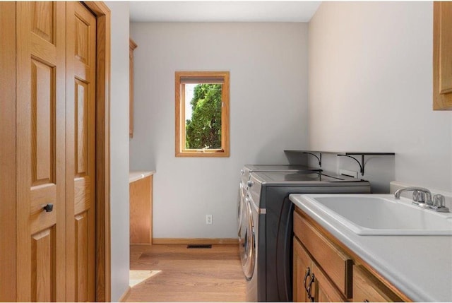 15210 Painters Lane Cir, Stillwater, MN 55082 - washroom featuring cabinet space, washing machine and dryer, light wood-style floors, and baseboards