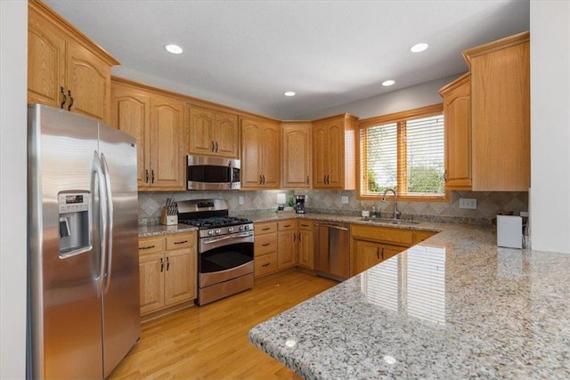 15210 Painters Lane Cir, Stillwater, MN 55082 - kitchen with stainless steel appliances, a sink, decorative backsplash, light stone countertops, and recessed lighting