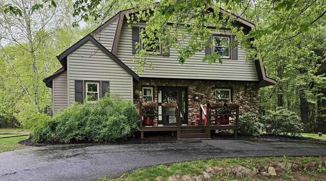 9388 Alpine Rd, Fremont, WI 54940 - view of front of house featuring stone siding, a gambrel roof, and a wooden deck